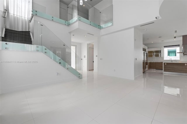 10431 NW 68th Ter, Doral, FL 33178 - unfurnished living room with stairway, a high ceiling, and light tile patterned floors