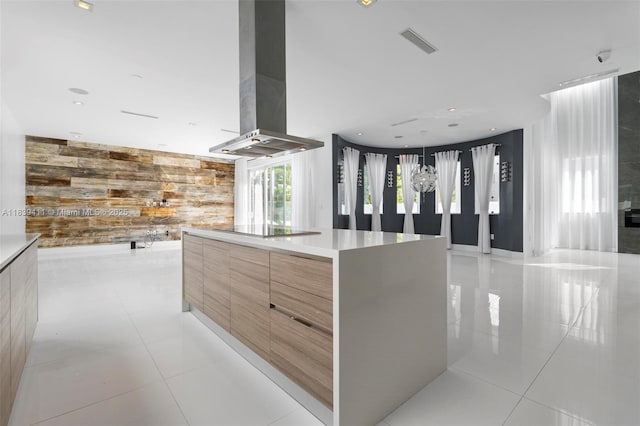 10431 NW 68th Ter, Doral, FL 33178 - kitchen featuring modern cabinets, wall chimney range hood, an accent wall, light tile patterned floors, and wood walls