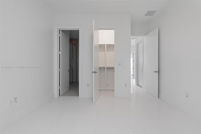 10431 NW 68th Ter, Doral, FL 33178 - unfurnished bedroom with a spacious closet and light tile patterned flooring