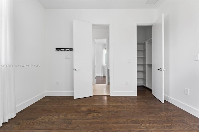 10431 NW 68th Ter, Doral, FL 33178 - unfurnished bedroom with a walk in closet and dark wood-style flooring