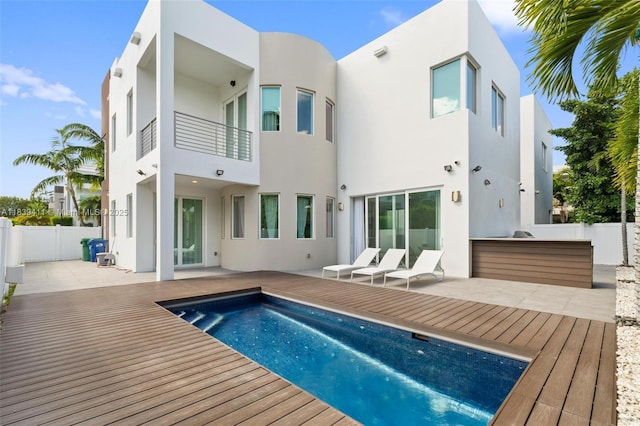 10431 NW 68th Ter, Doral, FL 33178 - rear view of house featuring stucco siding, a balcony, and a deck