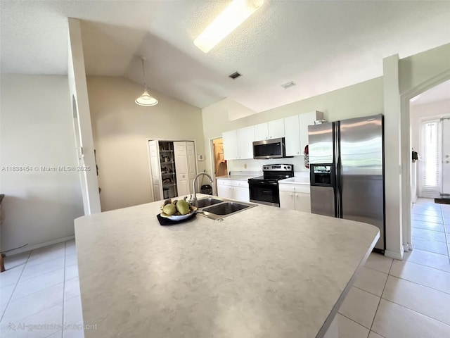 5338 NW S Crisona Cir, Port St Lucie, FL 34986 - kitchen with appliances with stainless steel finishes, white cabinetry, lofted ceiling, light tile patterned flooring, and light countertops