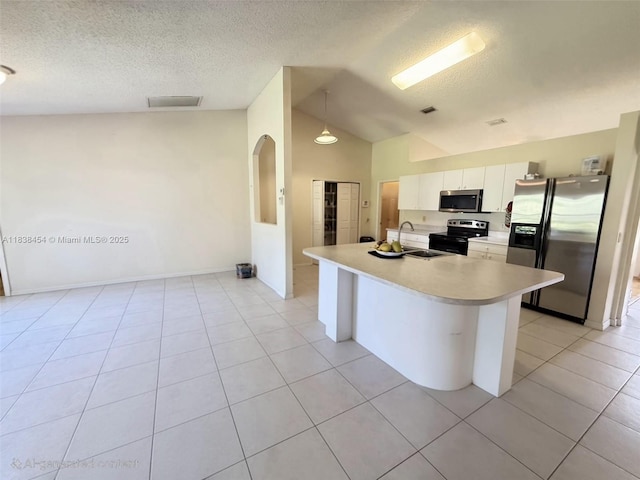 5338 NW S Crisona Cir, Port St Lucie, FL 34986 - kitchen featuring stainless steel appliances, lofted ceiling, light countertops, a textured ceiling, and white cabinetry