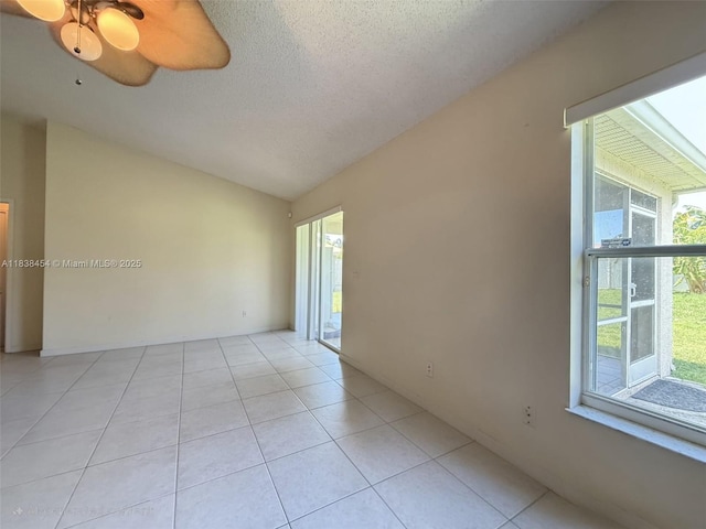 5338 NW S Crisona Cir, Port St Lucie, FL 34986 - spare room featuring lofted ceiling, light tile patterned flooring, a textured ceiling, and a ceiling fan