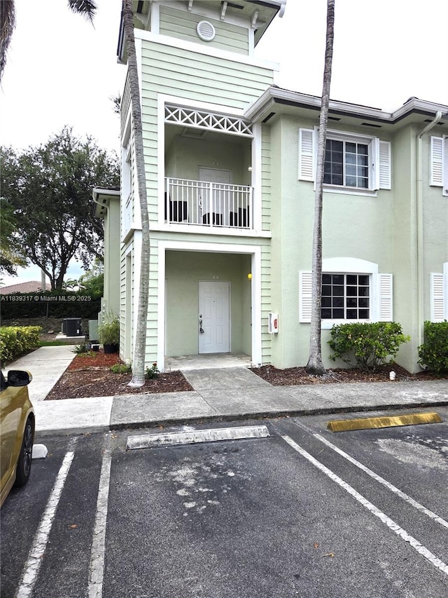 2630 NE 3rd Dr Unit 101, Homestead, FL 33033 - view of front of property with a balcony, uncovered parking, and stucco siding