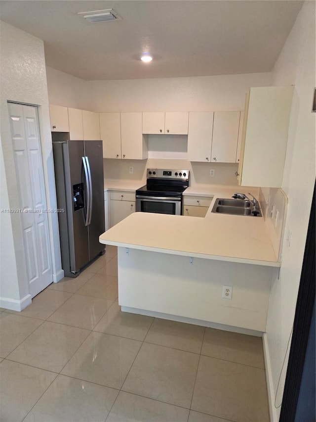 2630 NE 3rd Dr Unit 101, Homestead, FL 33033 - kitchen featuring appliances with stainless steel finishes, a peninsula, light countertops, and light tile patterned floors