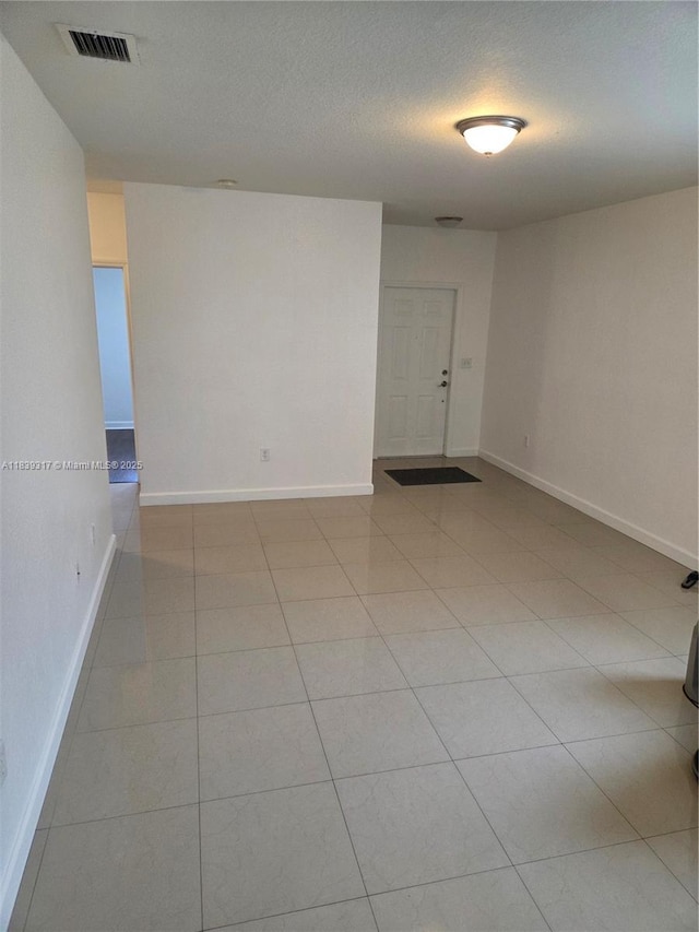 2630 NE 3rd Dr Unit 101, Homestead, FL 33033 - empty room with light tile patterned floors and a textured ceiling
