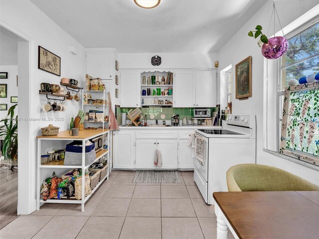 3210 E Elizabeth St, Miami, FL 33133 - kitchen with white electric stove, open shelves, white cabinets, backsplash, and light tile patterned floors