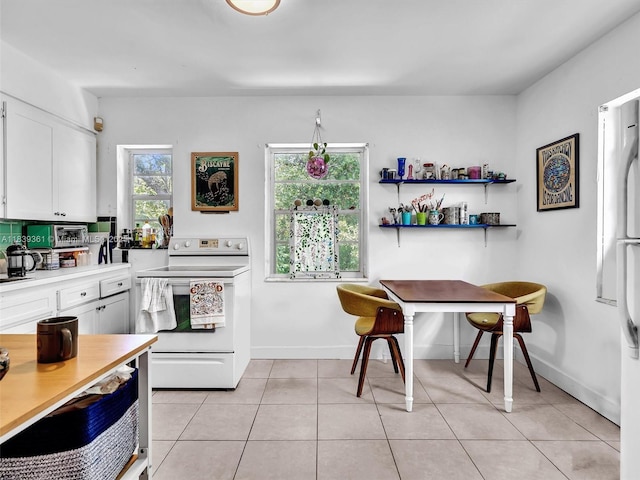 3210 E Elizabeth St, Miami, FL 33133 - kitchen with electric range, white cabinets, light tile patterned flooring, and light countertops