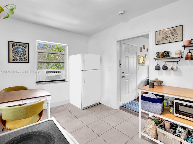 3210 E Elizabeth St, Miami, FL 33133 - kitchen featuring freestanding refrigerator, light tile patterned floors, cooling unit, and stainless steel microwave