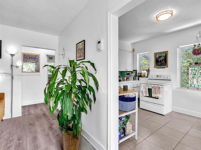 3210 E Elizabeth St, Miami, FL 33133 - kitchen featuring white electric stove, light countertops, white cabinetry, and light tile patterned flooring
