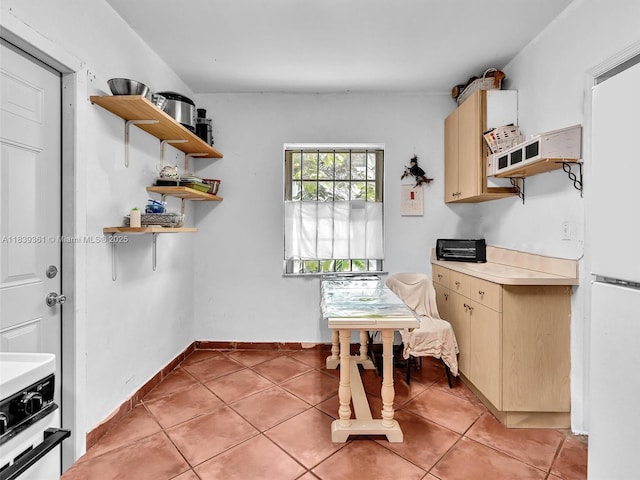 3210 E Elizabeth St, Miami, FL 33133 - kitchen with open shelves, light countertops, light tile patterned floors, and range