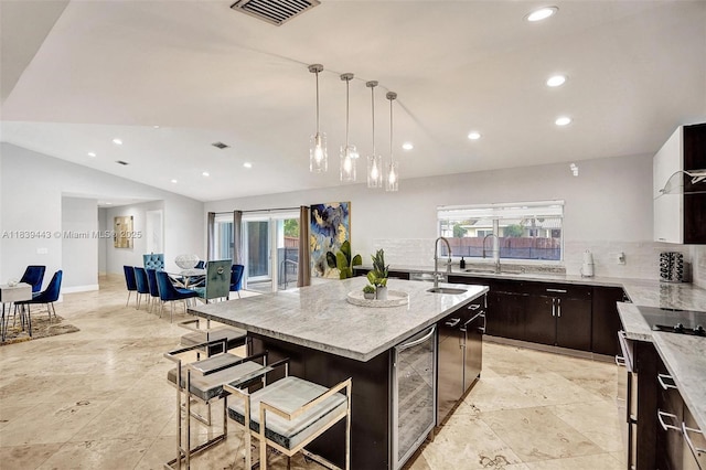 614 SE 12th Ave, Deerfield Beach, FL 33441 - kitchen with lofted ceiling, wine cooler, tasteful backsplash, recessed lighting, and a center island with sink