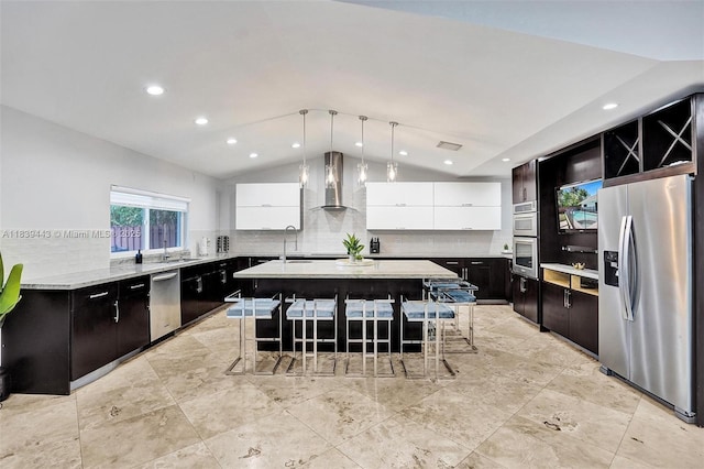 614 SE 12th Ave, Deerfield Beach, FL 33441 - kitchen featuring appliances with stainless steel finishes, vaulted ceiling, backsplash, wall chimney exhaust hood, and a center island