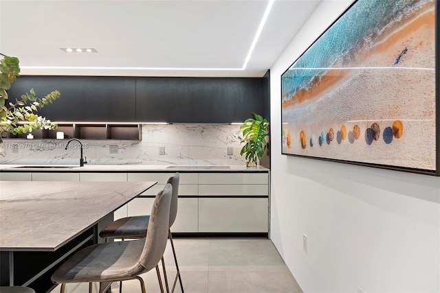 2301 Collins Ave Unit 1004/1003, Miami Beach, FL 33139 - kitchen with backsplash, light stone counters, and modern cabinets