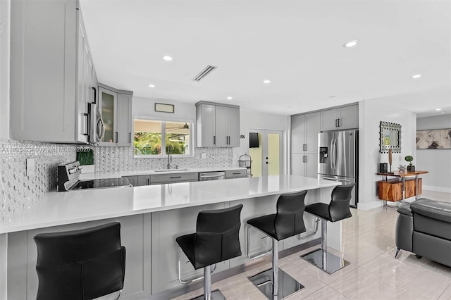 8115 NW 185th Ter, Hialeah, FL 33015 - kitchen featuring stainless steel appliances, gray cabinets, decorative backsplash, a peninsula, and recessed lighting