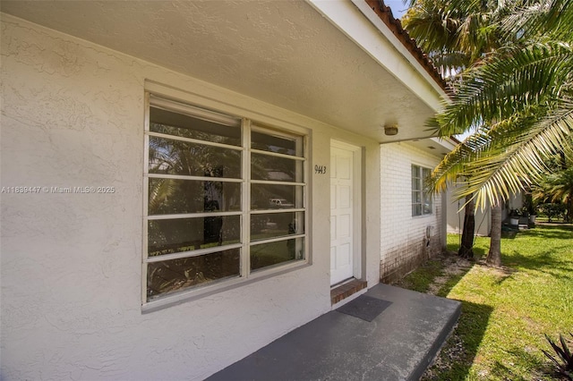 9443 SW 174th St Unit 9443, Palmetto Bay, FL 33157 - doorway to property with brick siding, stucco siding, and a yard