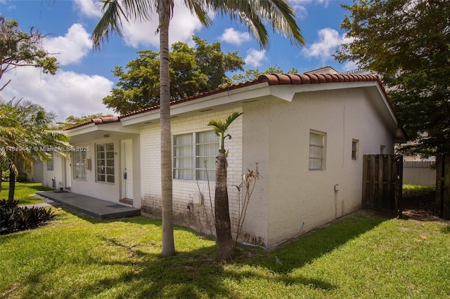 9443 SW 174th St Unit 9443, Palmetto Bay, FL 33157 - view of side of home with a yard, brick siding, a tile roof, and stucco siding