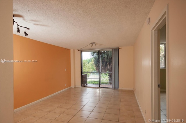 2821 N Miami Beach Blvd Unit 2E, North Miami Beach, FL 33160 - empty room with light tile patterned floors and a textured ceiling