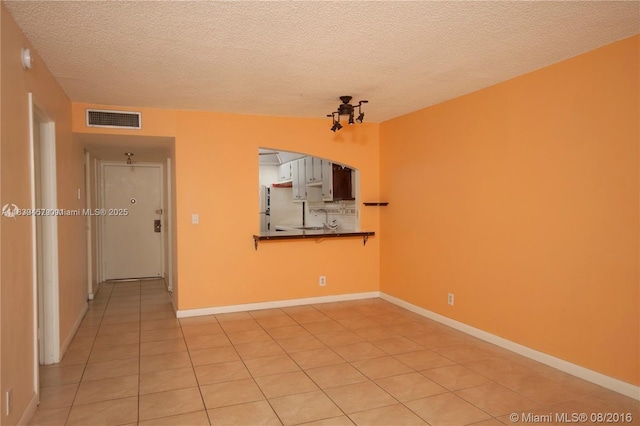 2821 N Miami Beach Blvd Unit 2E, North Miami Beach, FL 33160 - empty room featuring light tile patterned floors and a textured ceiling