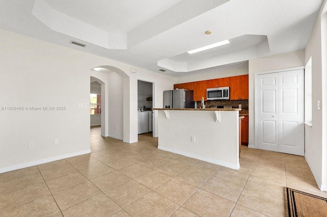 3066 S Red Mangrove Ln S Unit 201-2, Dania Beach, FL 33312 - kitchen with appliances with stainless steel finishes, a raised ceiling, light tile patterned floors, and arched walkways