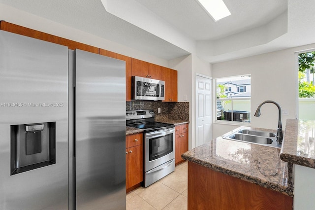 3066 S Red Mangrove Ln S Unit 201-2, Dania Beach, FL 33312 - kitchen featuring stainless steel appliances, brown cabinetry, tasteful backsplash, and light tile patterned floors