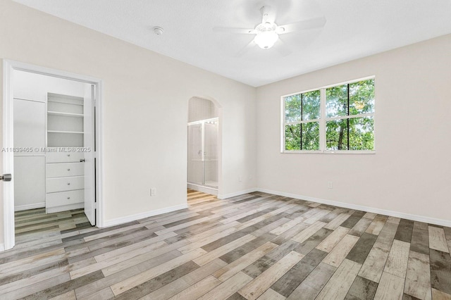 3066 S Red Mangrove Ln S Unit 201-2, Dania Beach, FL 33312 - unfurnished bedroom featuring arched walkways, light wood-style floors, a spacious closet, and ceiling fan