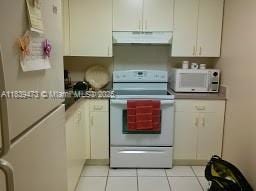 5755 W 20th Ave Unit 206, Hialeah, FL 33012 - kitchen featuring white appliances, extractor fan, white cabinets, and light tile patterned floors