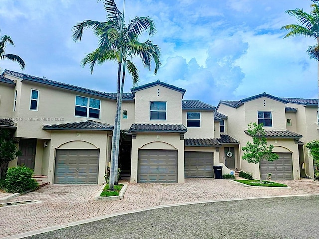 1900 Oceanwalk Ln Unit 123, Lauderdale By The Sea, FL 33062 - mediterranean / spanish house featuring an attached garage, driveway, stucco siding, and a tile roof