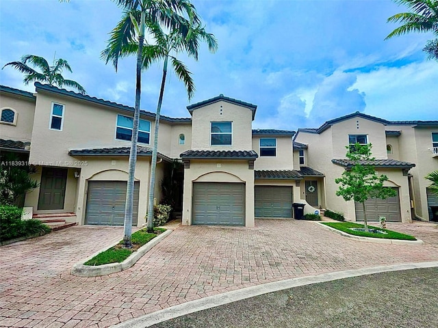 1900 Oceanwalk Ln Unit 123, Lauderdale By The Sea, FL 33062 - mediterranean / spanish house with an attached garage, decorative driveway, stucco siding, and a tiled roof