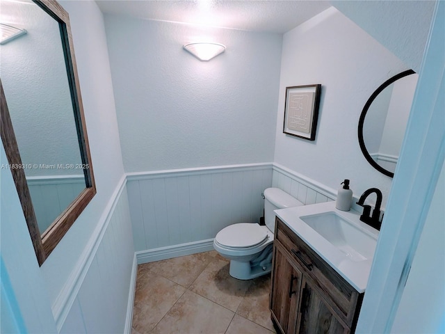 1900 Oceanwalk Ln Unit 123, Lauderdale By The Sea, FL 33062 - half bathroom featuring vanity, a wainscoted wall, and tile patterned floors