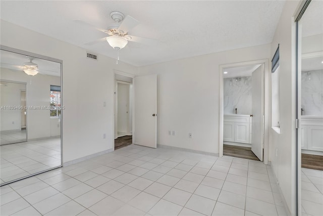 37 Majorca Ave Unit 401, Coral Gables, FL 33134 - unfurnished bedroom with light tile patterned floors, a ceiling fan, a textured ceiling, a closet, and connected bathroom