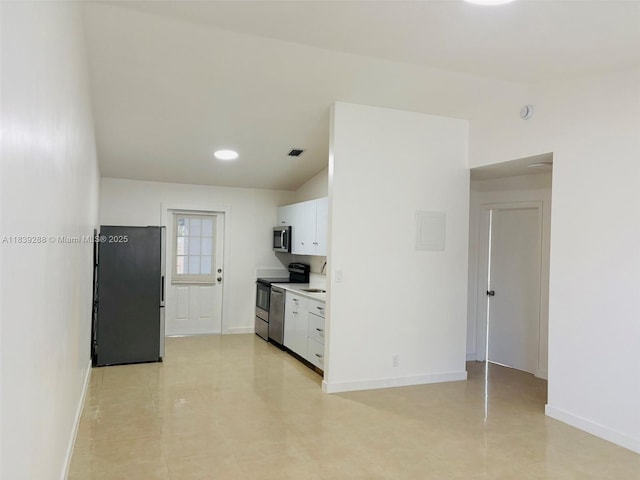 4710 NW 3rd Ter, Deerfield Beach, FL 33064 - kitchen with appliances with stainless steel finishes, white cabinetry, light countertops, vaulted ceiling, and light tile patterned floors