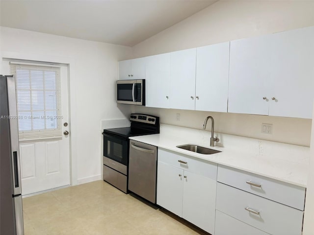 4710 NW 3rd Ter, Deerfield Beach, FL 33064 - kitchen featuring stainless steel appliances, light countertops, white cabinets, and vaulted ceiling