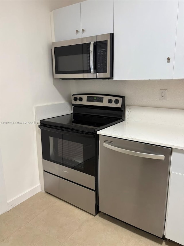 4710 NW 3rd Ter, Deerfield Beach, FL 33064 - kitchen featuring stainless steel appliances, light countertops, white cabinetry, and light tile patterned floors