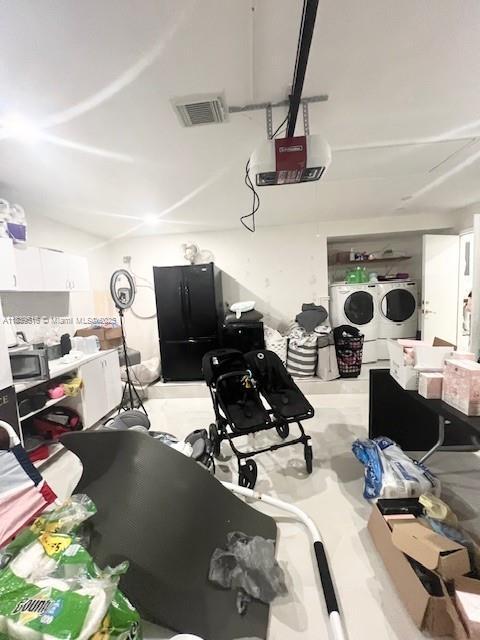 4966 SW 33rd Ter, Hollywood, FL 33312 - garage featuring independent washer and dryer, freestanding refrigerator, and a garage door opener