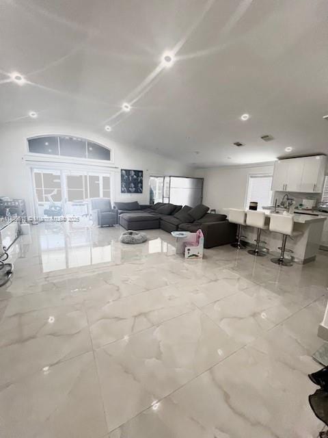 4966 SW 33rd Ter, Hollywood, FL 33312 - living room featuring marble tiled floors, healthy amount of natural light, and vaulted ceiling