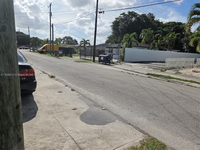 2936 NW 47th St, Miami, FL 33142 - view of asphalt road featuring sidewalks and a gate