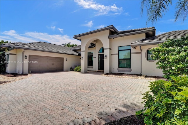 17809 Southwick Way, Boca Raton, FL 33498 - prairie-style house featuring stucco siding, decorative driveway, an attached garage, and a tiled roof