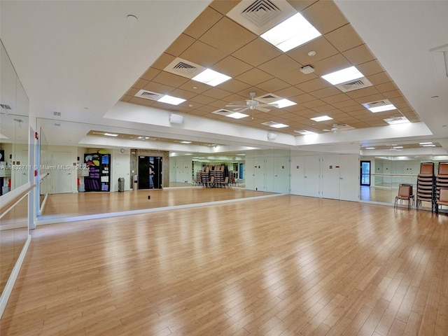 17809 Southwick Way, Boca Raton, FL 33498 - exercise room with light wood finished floors, a ceiling fan, a paneled ceiling, and a tray ceiling