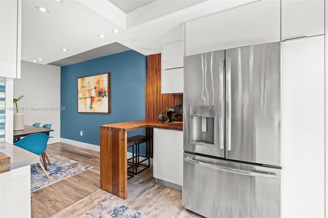 640 NW 98th Ct Unit 640, Miami, FL 33172 - kitchen with stainless steel fridge, white cabinetry, modern cabinets, light wood-style flooring, and recessed lighting