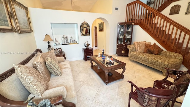 15588 SW 62nd St, Miami, FL 33193 - living room featuring arched walkways, light tile patterned flooring, high vaulted ceiling, and stairs