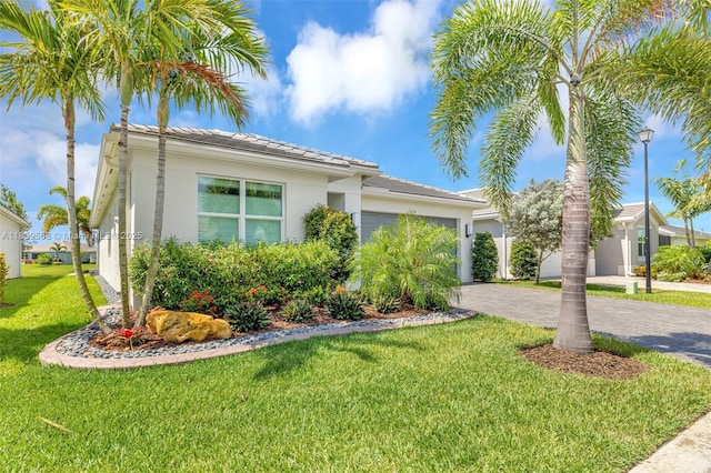 15734 SW Egret Coast Dr, Port St Lucie, FL 34987 - view of front of property featuring a garage, stucco siding, decorative driveway, a front yard, and a tiled roof