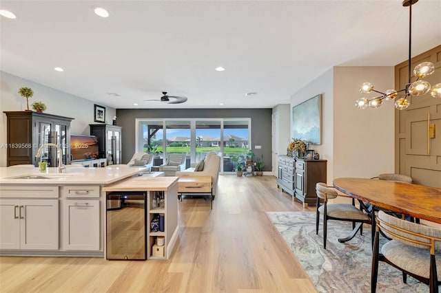 15734 SW Egret Coast Dr, Port St Lucie, FL 34987 - kitchen featuring beverage cooler, open floor plan, light wood-style floors, light countertops, and a chandelier