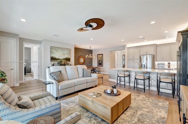 15734 SW Egret Coast Dr, Port St Lucie, FL 34987 - living area with a chandelier, a ceiling fan, light wood finished floors, and recessed lighting