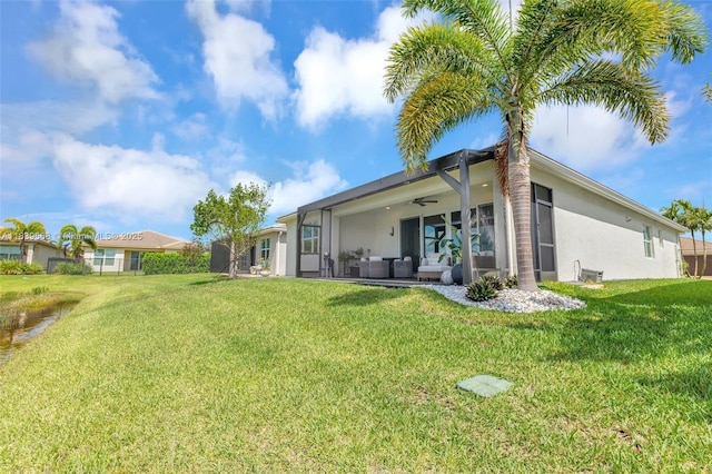 15734 SW Egret Coast Dr, Port St Lucie, FL 34987 - rear view of property with stucco siding, a yard, and a ceiling fan