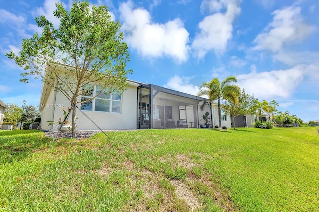 15734 SW Egret Coast Dr, Port St Lucie, FL 34987 - rear view of house featuring a lawn, stucco siding, and glass enclosure