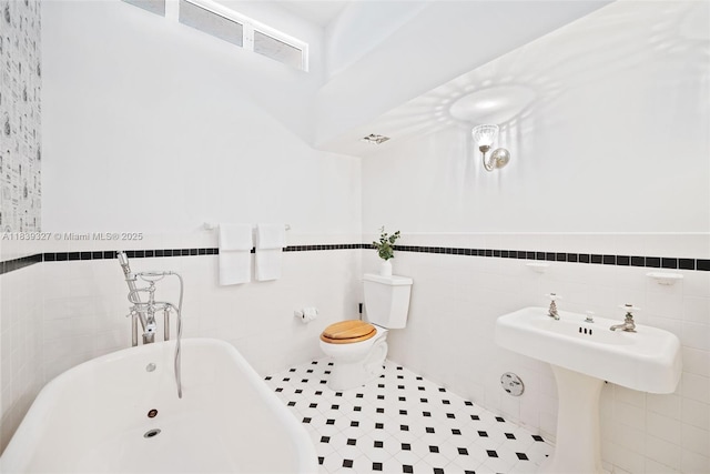 7545 Banyan Way, Tamarac, FL 33321 - bathroom with tile walls, a soaking tub, tile patterned flooring, and a wainscoted wall