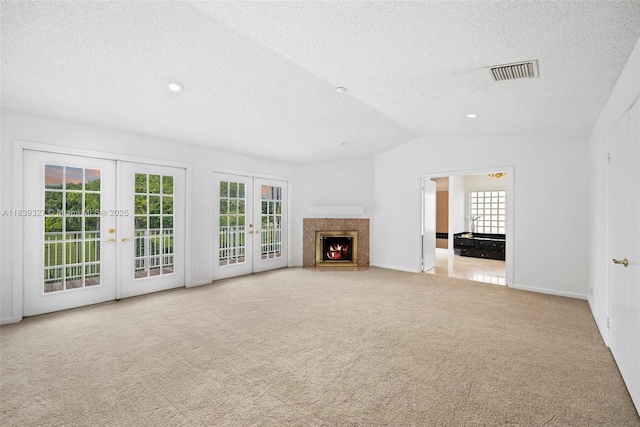 7545 Banyan Way, Tamarac, FL 33321 - unfurnished living room with french doors, a textured ceiling, carpet flooring, plenty of natural light, and vaulted ceiling