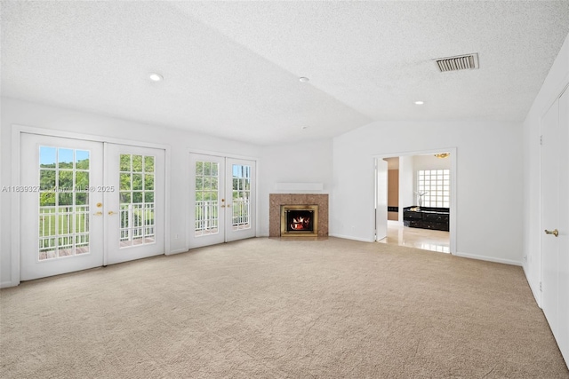 7545 Banyan Way, Tamarac, FL 33321 - unfurnished living room featuring french doors, a textured ceiling, carpet, lofted ceiling, and a high end fireplace
